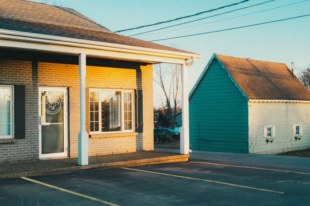 Stock photo: small brick house with a white porch beside a green garage